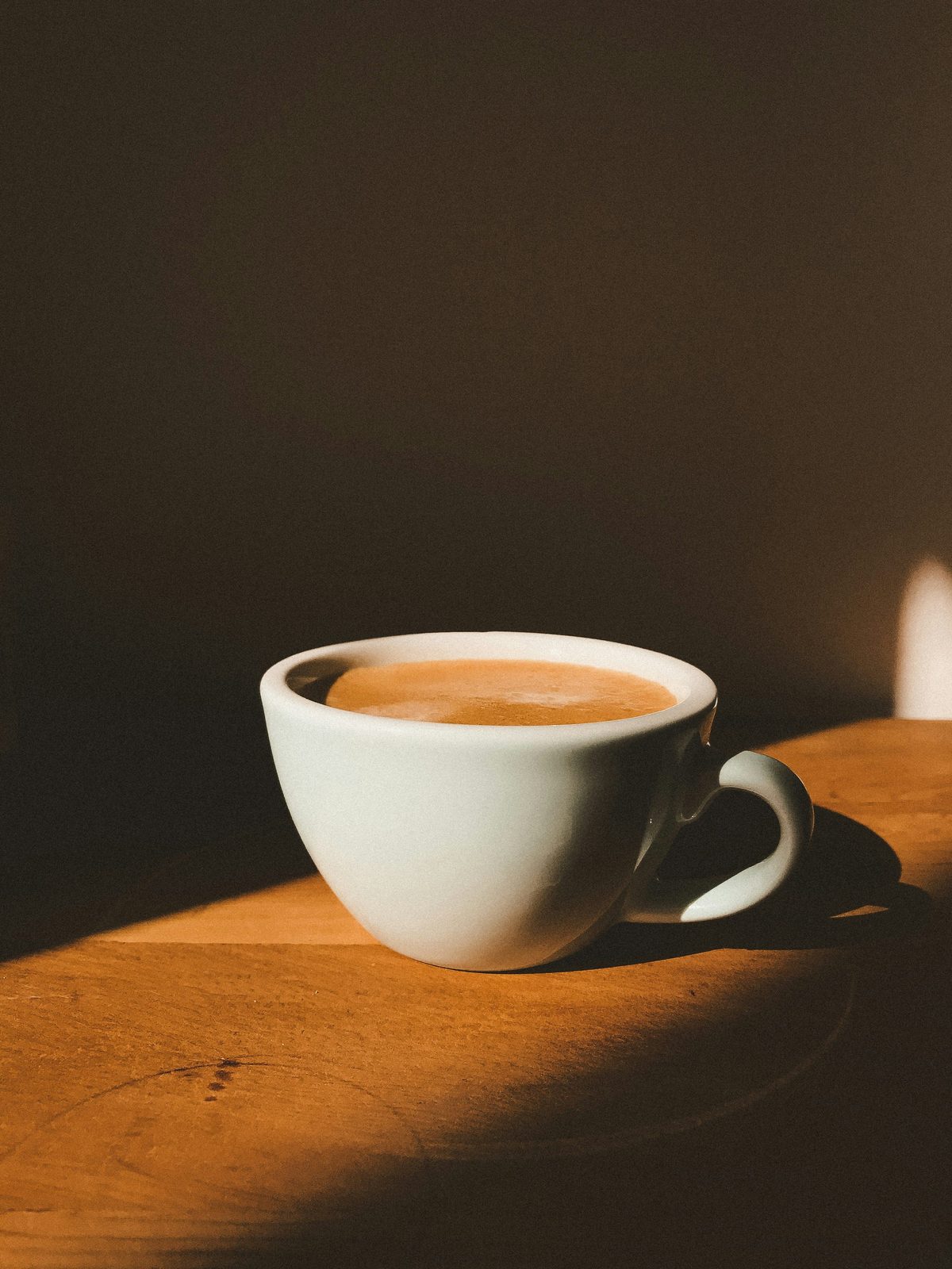 Kop kaffe i varmt lys på et bord
