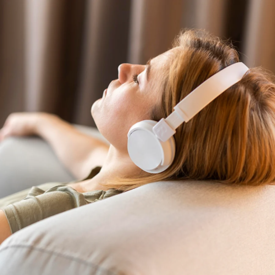 Kvinde med hovedtelefoner der lytter til en guidet pause